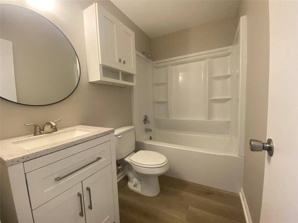 Further down the hallway on your left you will find the bathroom. A fully remodeled space: new tub/shower combo, vanity, mirror, and toilet.