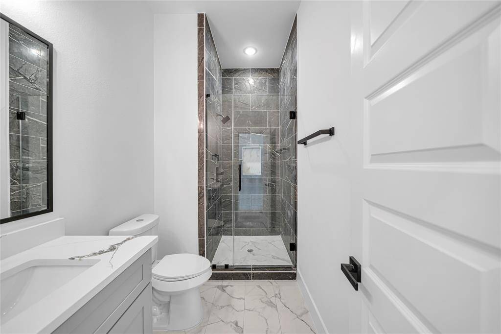 Secondary bathroom with extended marble in shower.