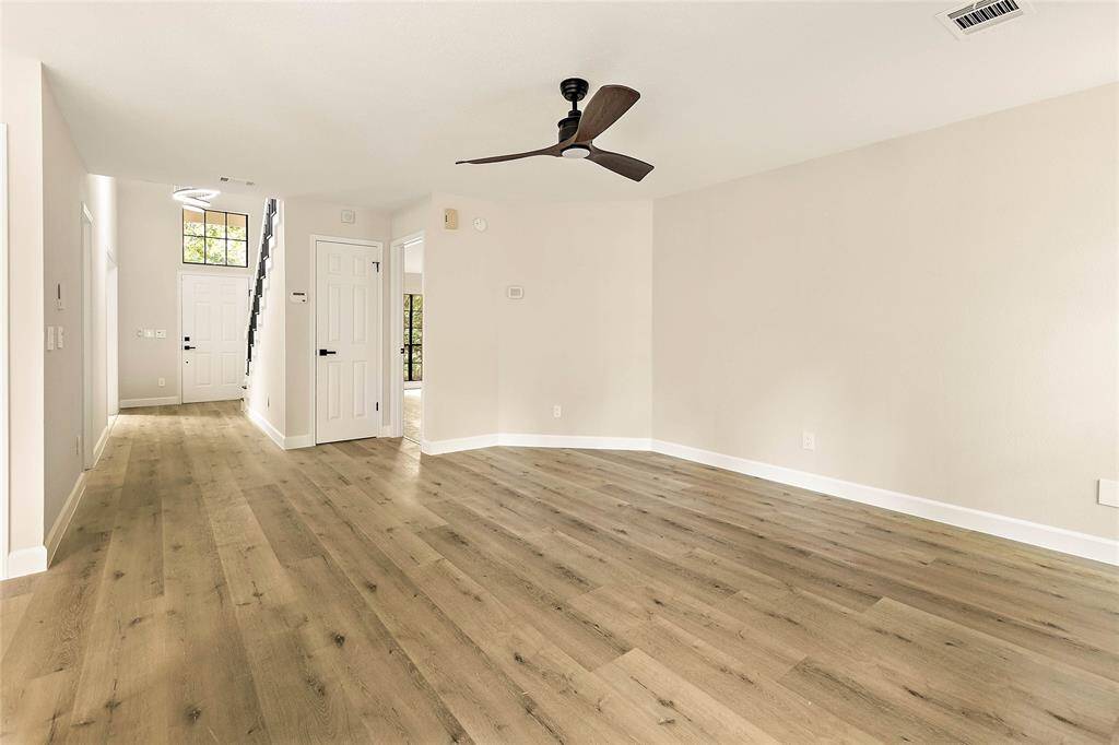 With its considerable dimensions, the family room has light-toned luxury vinyl flooring, neutral walls, and a modern ceiling fan. The open layout flows perfectly for entertaining or family time.