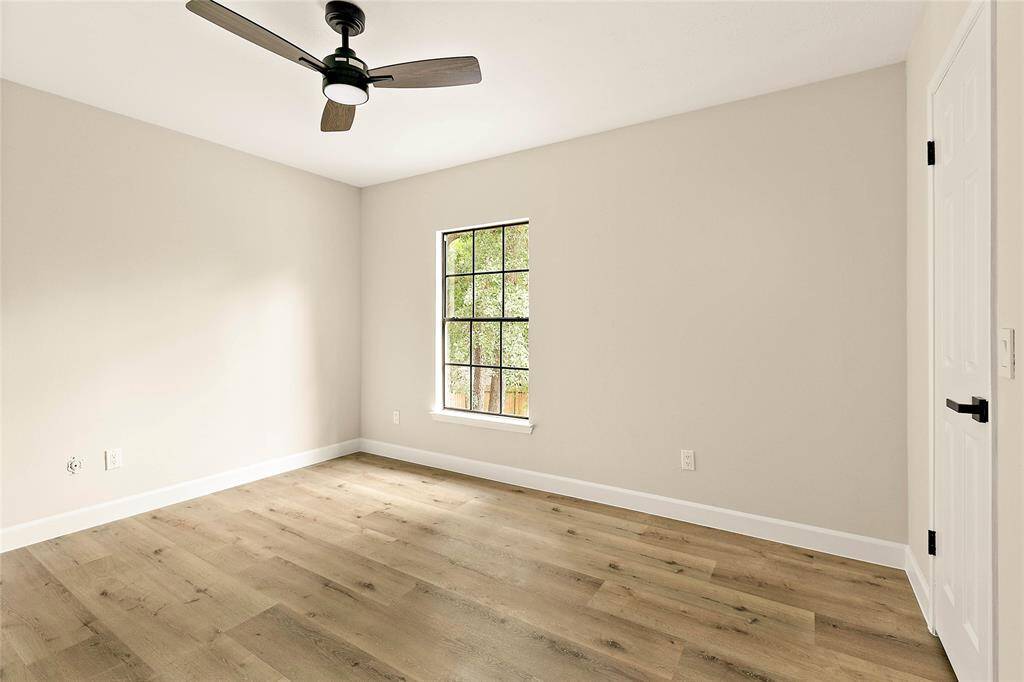 Spacious secondary bedroom offers a bright atmosphere with a large window, ceiling fan, and generous closet.