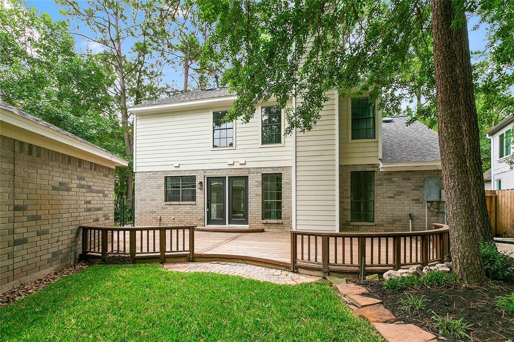 Enjoy this appealing backyard with a spacious wooden deck, perfect for entertaining. A true oasis!