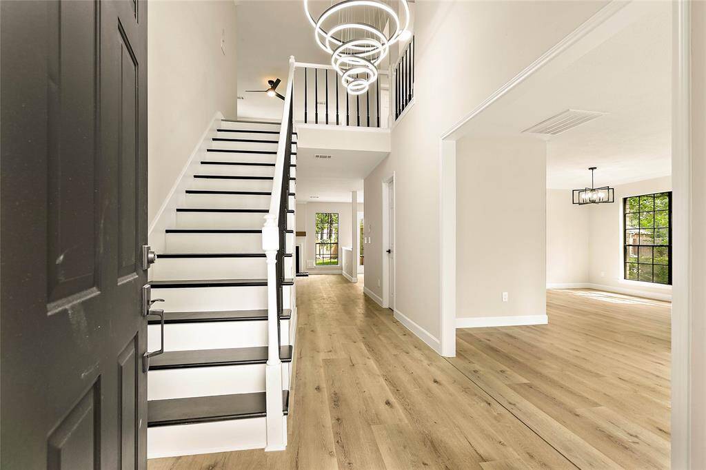 The front entry welcomes you and your guests home with a wooden staircase and a modern chandelier. Beautiful flooring floors flow throughout the home.