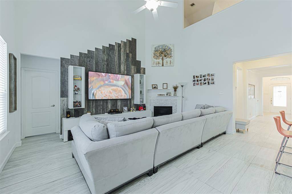 Cozy up in the living room with high ceiling, fireplace and views of the backyard.
