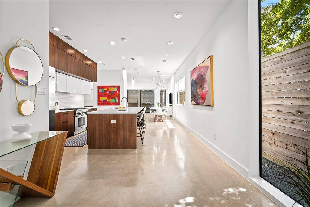 The entryway seamlessly flows into the home's modern kitchen and open living space, creating a natural and inviting transition.