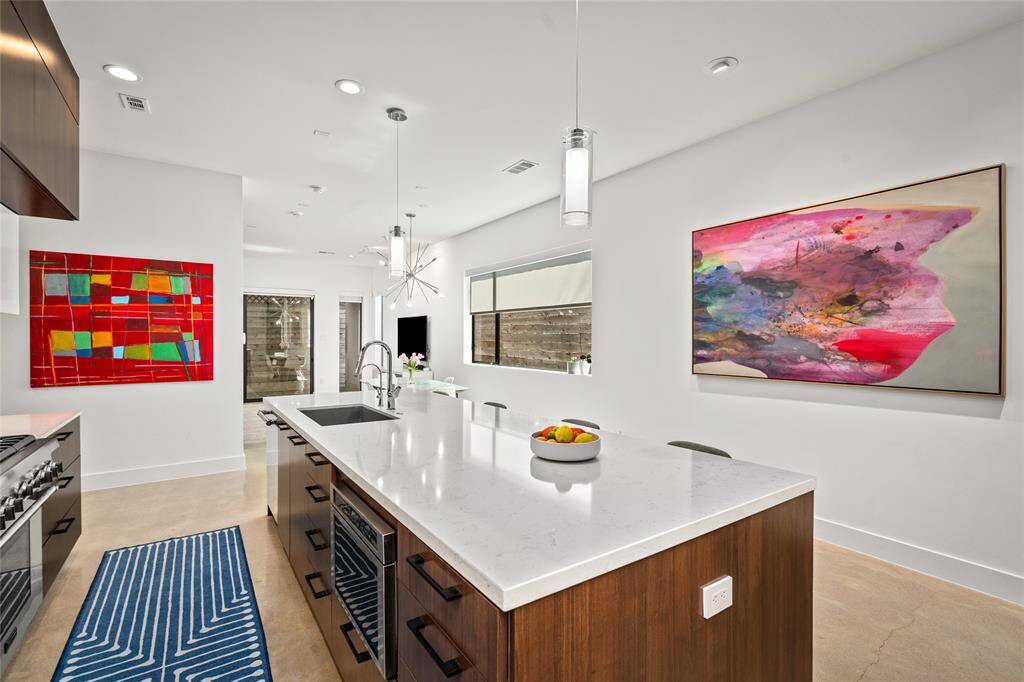 The expansive kitchen island features a built-in Thermador Masterpiece Professional Series microwave and a seamlessly integrated dishwasher.