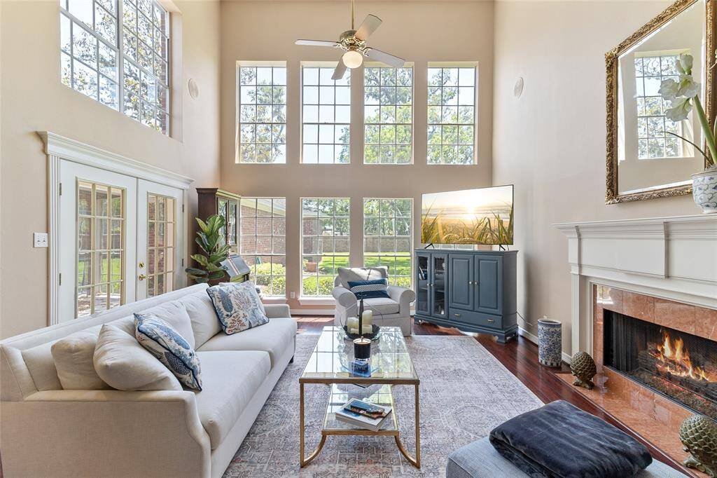 Bask in natural light in this breathtaking family room, where a soaring ceiling and a full wall of windows frame serene views of the backyard & create an airy, inviting atmosphere.