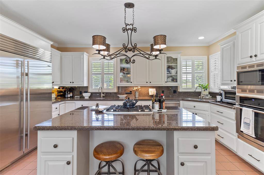 Beautifully designed kitchen featuring a high-end Sub-Zero refrigerator, stainless steel appliances & granite countertops—blending style & practicality with ample counter space and custom cabinetry for effortless meal prep and entertaining.