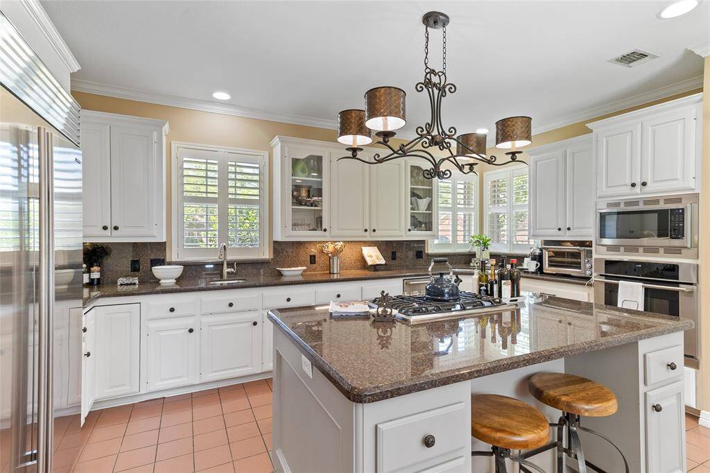Designed with functionality in mind, this kitchen includes a convenient second prep sink & a picturesque corner window that fills the space with natural light—making everyday tasks feel bright & effortless.