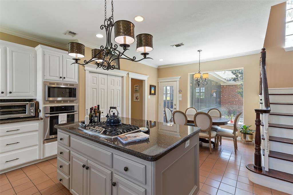 This bright kitchen & breakfast nook combo features a spacious pantry with built-in storage to keep everything organized & accessible + views of the second staircase that leads to the upstairs loft & second living area.