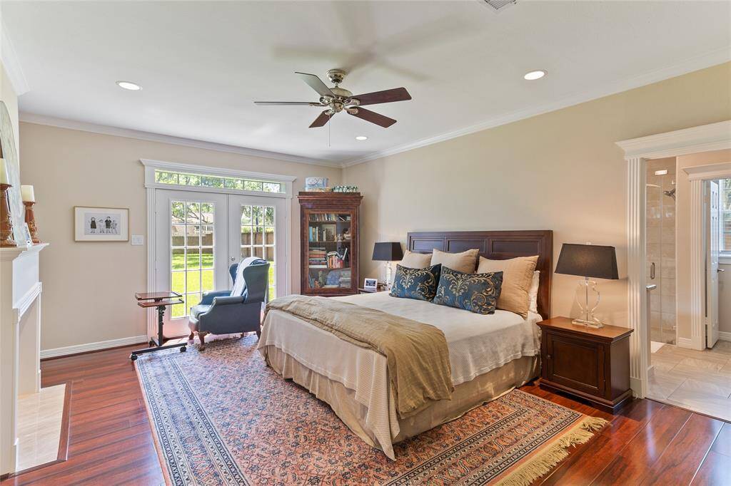 This generously sized primary bedroom (18x16) is a true retreat, featuring French doors that open to the backyard with views into the luxurious en-suite bathroom—combining comfort, elegance & serenity.