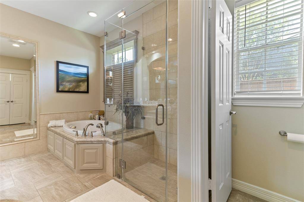 Expansive primary en-suite bath is as functional as it is luxurious, featuring a private water closet tucked discreetly beside the oversized shower & soaking tub to round out this beautifully appointed space.