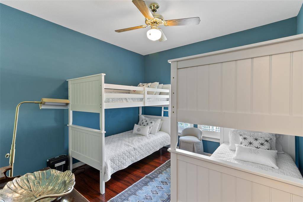Well-sized (11x11) downstairs Bedroom #2 boasts rich laminate wood flooring & timeless plantation shutters, creating a warm, comfortable & inviting space.