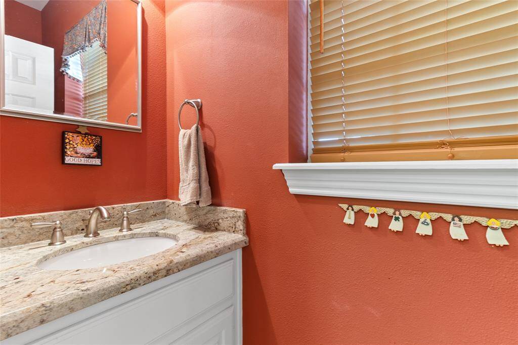 Conveniently located just off the kitchen, this charming half bath offers a welcoming space for guests, complete with granite countertops & updated fixtures for a polished, timeless touch.