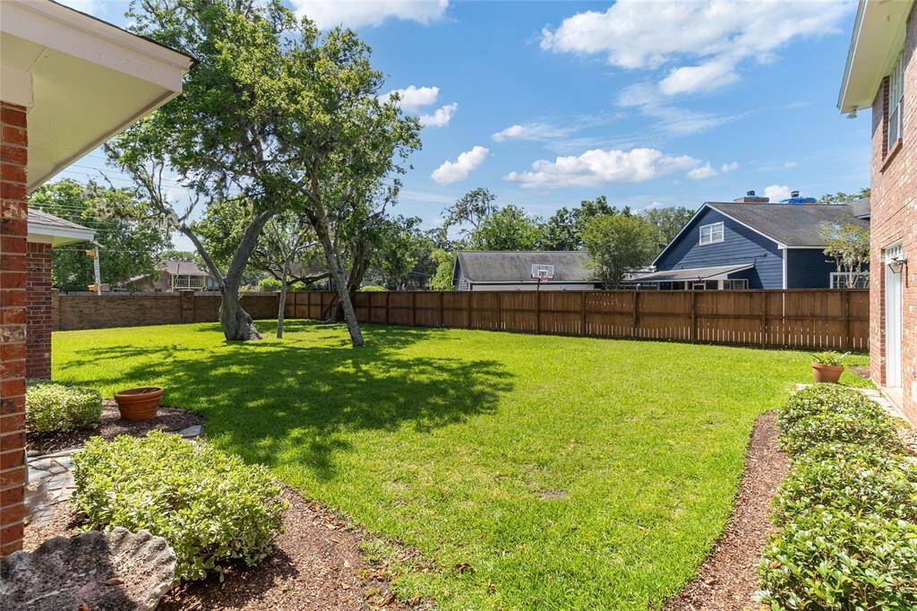 Step out from the screened-in patio into this beautifully maintained backyard—offering lush green space, mature trees & plenty of room for play, gardening, or future outdoor additions.