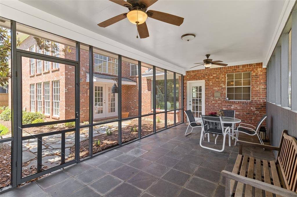 Spacious (26x11) screened-in back porch offering a shaded retreat for year-round enjoyment with direct access to the kitchen & breakfast area—ideal for bringing in groceries from the driveway or garage with ease.