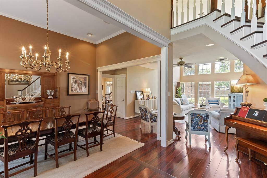A stunning first impression—engineered hardwood floors flow seamlessly from the formal dining room into the soaring family room, creating a warm, cohesive feel & instant wow factor from the moment you walk in.