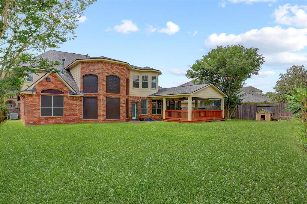 The fully fenced backyard features a large grassy area perfect for play, pets, or weekend gatherings.