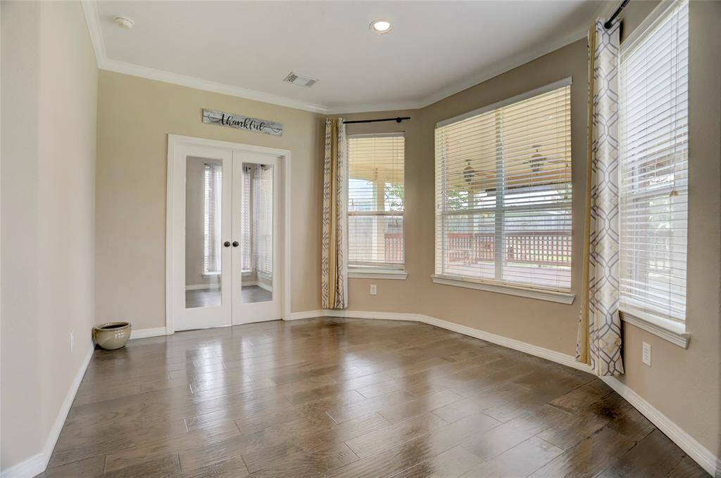 The sunroom offers a quiet retreat lined with tall windows and a serene view of the backyard.