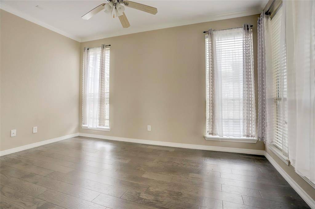 A secondary living space or front room offers flexible use with neutral tones and hardwood floors.