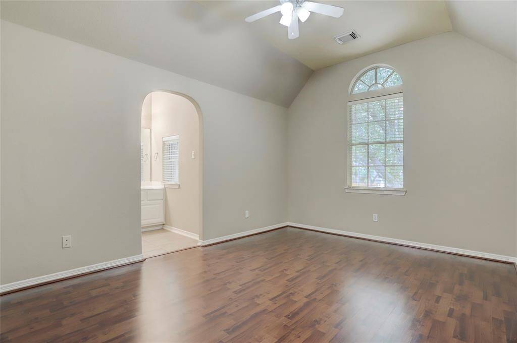 Upstairs bedroom with vaulted ceiling and wood flooring gives a warm and inviting atmosphere.