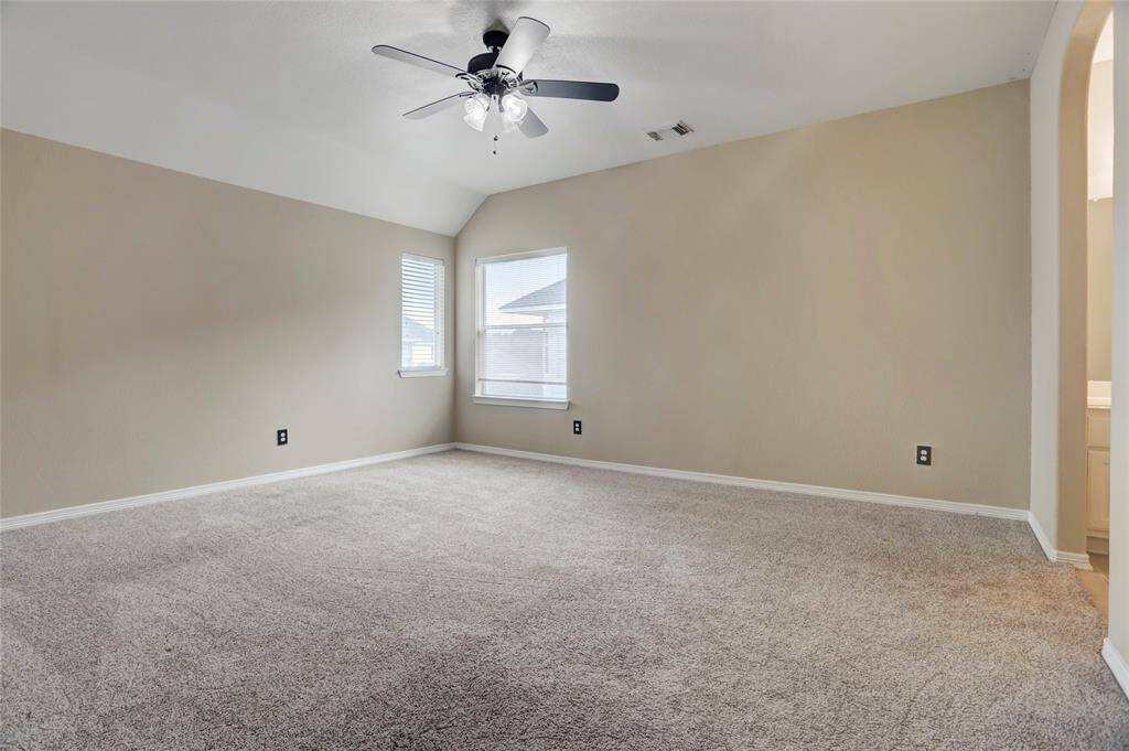 Carpeted secondary bedroom features a ceiling fan and flexible space for furniture arrangement.