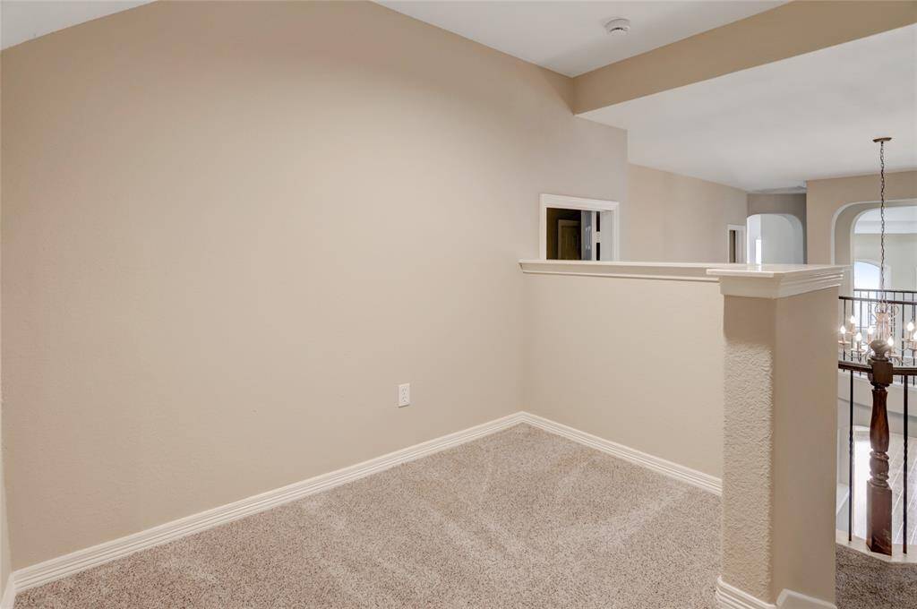 The upstairs hallway offers open sightlines and connects the secondary bedrooms and flex space.