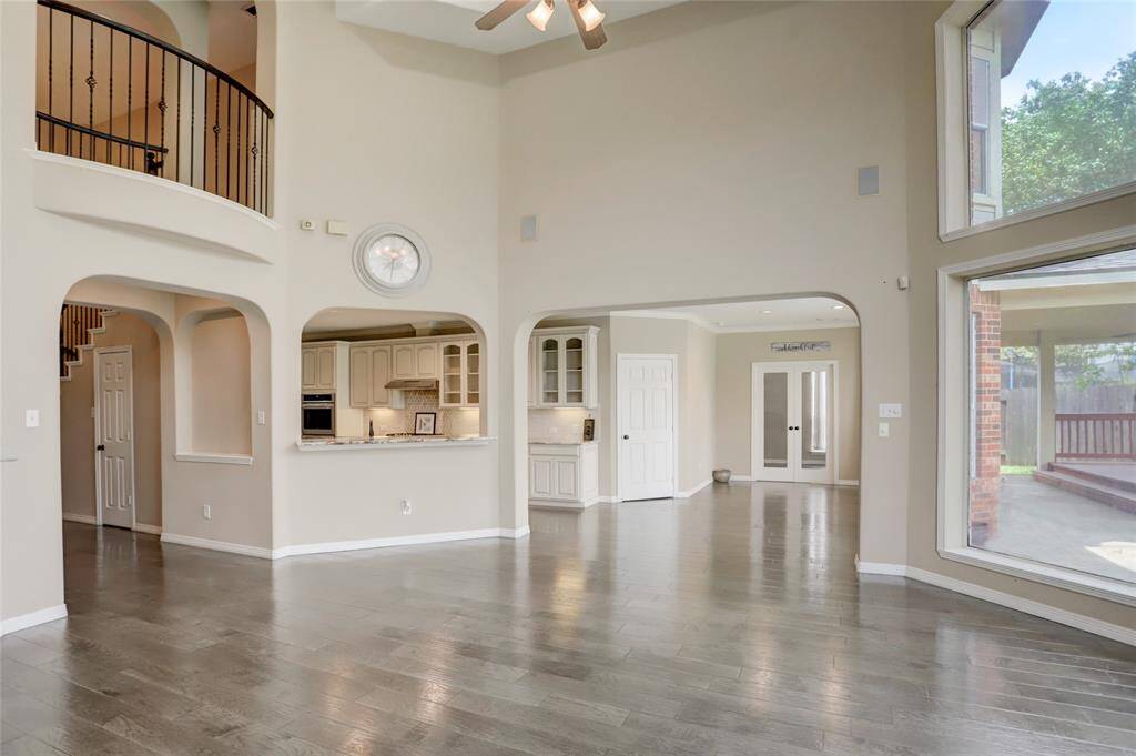 An open-concept design with dramatic ceiling height and expansive windows fills the home with natural light and grandeur.