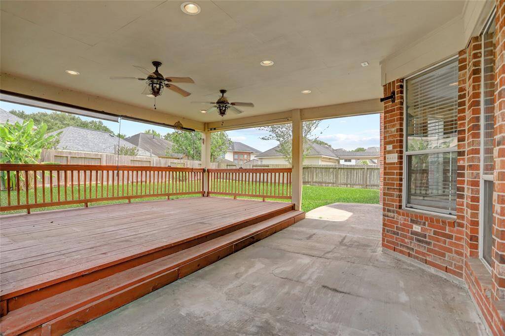 Enjoy outdoor living on this covered patio with dual ceiling fans and space for seating or dining.