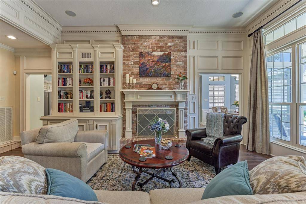Cozy up by the brick fireplace surrounded by stunning built-in shelves—offering warmth, style, and functional storage.