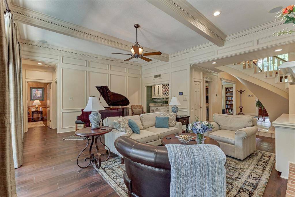 Spacious and elegant main living area with detailed trim, beamed ceilings, rich wood-look flooring, and seamless flow throughout.