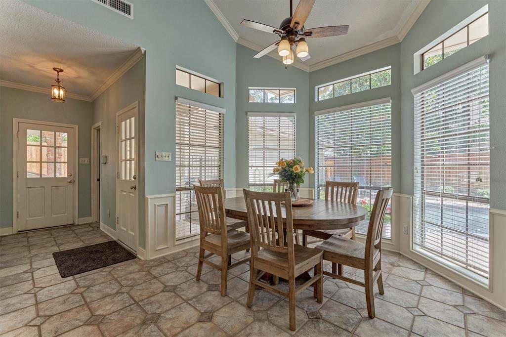 Charming breakfast nook surrounded by windows with peaceful views of the pool and patio—an inviting space to start your day.