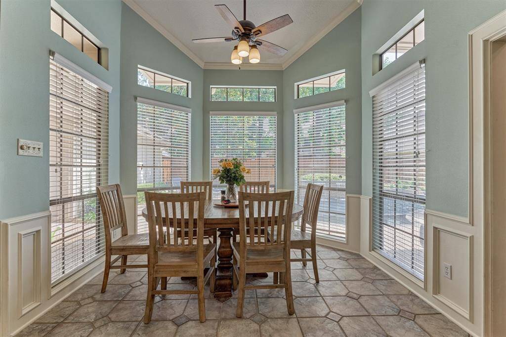 Light-filled dining, transom windows, and panoramic views of the lush backyard retreat.