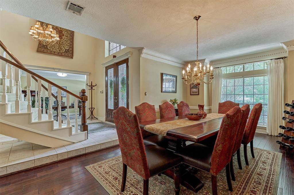 Formal dining room with elegant chandelier, detailed crown molding, and a large picture window—perfectly located off the foyer for seamless entertaining.