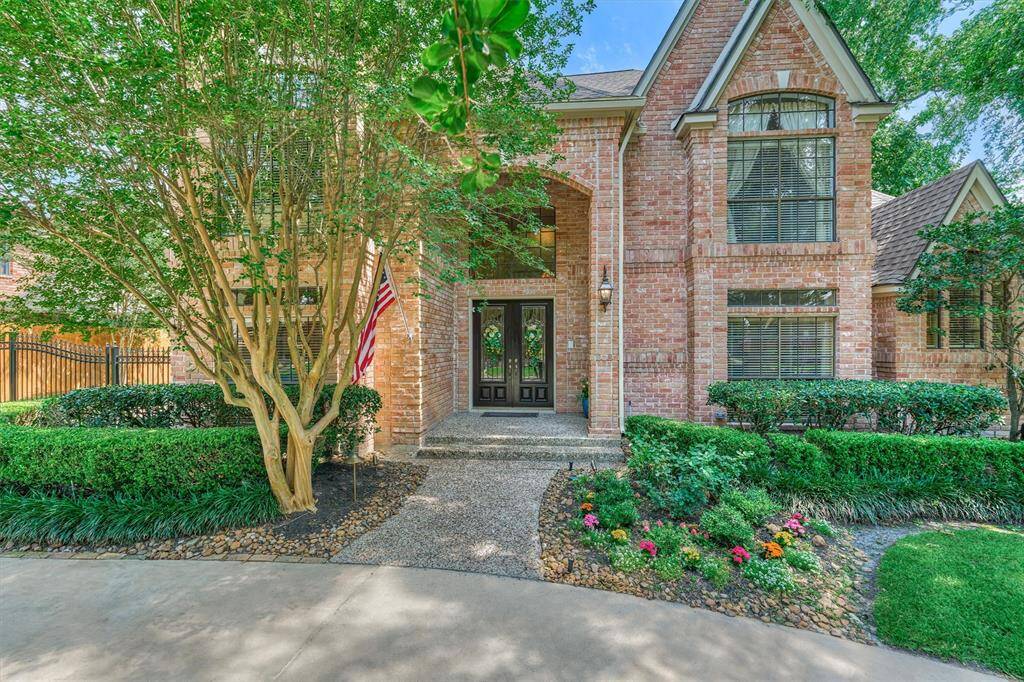 Charming curb appeal with manicured landscaping, brick façade, double front doors, and a tree-lined entry that welcomes you home.