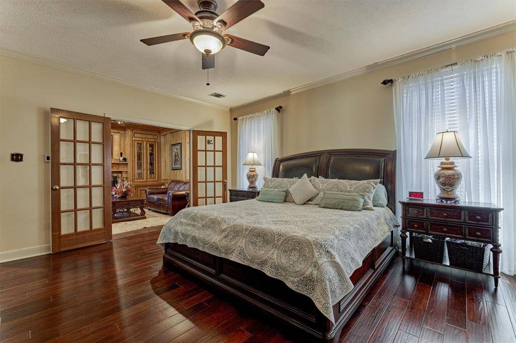 Primary bedroom features French doors leading to an attached sitting room, office, or library—tailor this versatile space to fit your lifestyle.