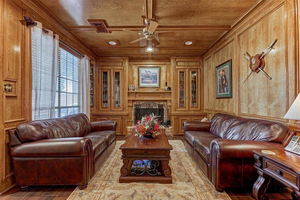 Sophisticated flex space just off the primary suite, complete with custom wood paneling, fireplace, built-ins, and a cozy ambiance—ideal as a private library, den, or executive office.