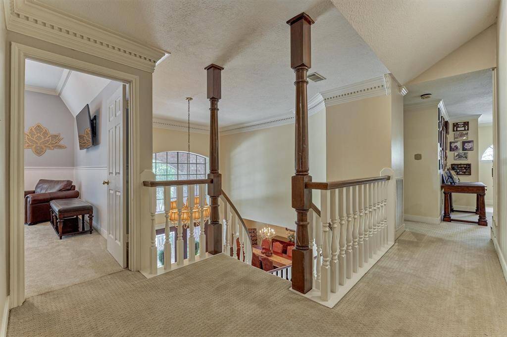 Dual staircases converge on this spacious landing, connecting the upstairs bedrooms, gameroom, and flex spaces with style and function.