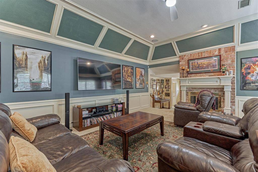 Spacious upstairs game room with cozy fireplace, dramatic trim detail, and plenty of room for lounging or entertaining.