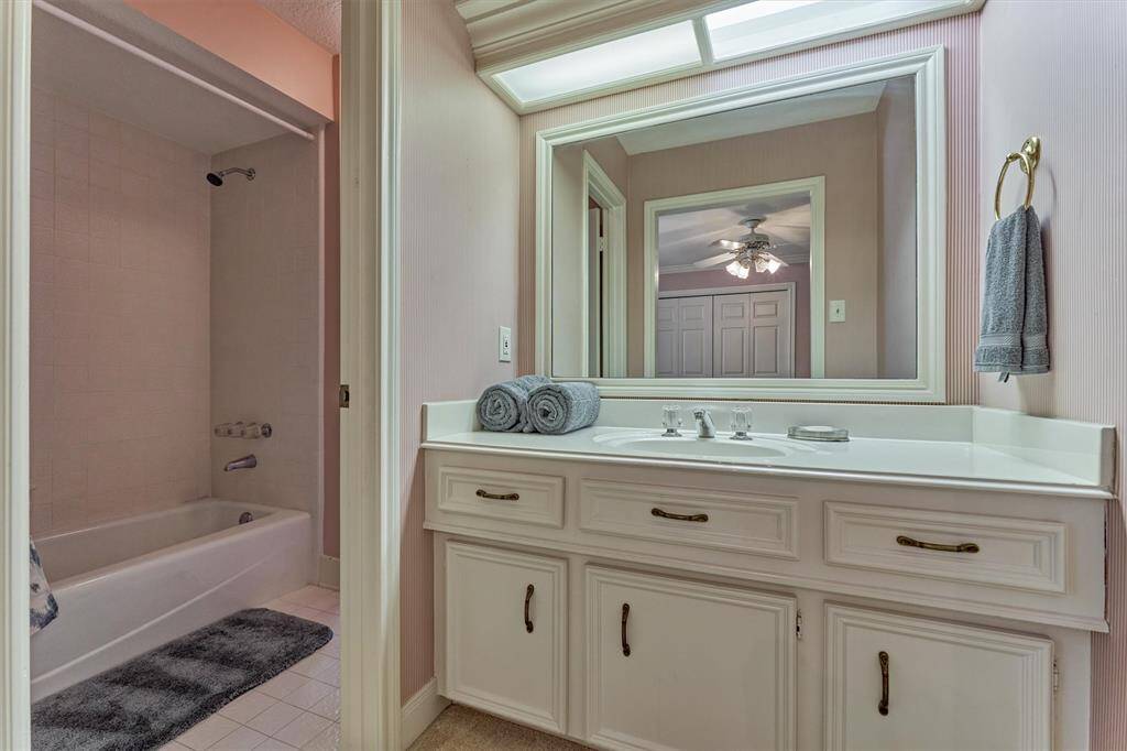 The connecting bathroom features dual vanities and timeless finishes, creating a comfortable shared space between the bedroom and the flex room.