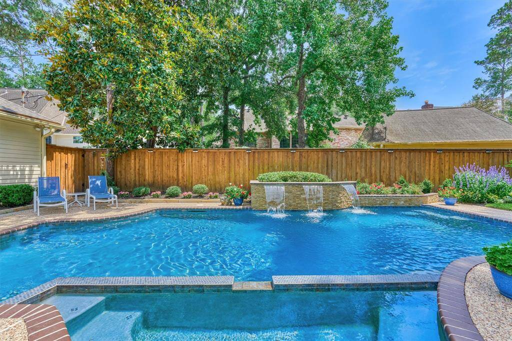 Backyard Oasis – Sparkling pool with triple waterfall feature, surrounded by lush landscaping and plenty of space to lounge and soak up the sun.