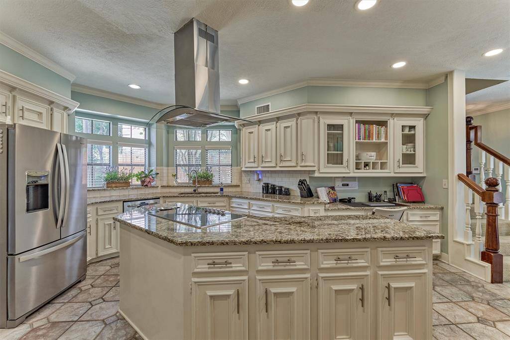 Spacious chef’s kitchen with granite countertops, custom cabinetry, large center island, stainless steel appliances, and an abundance of natural light.