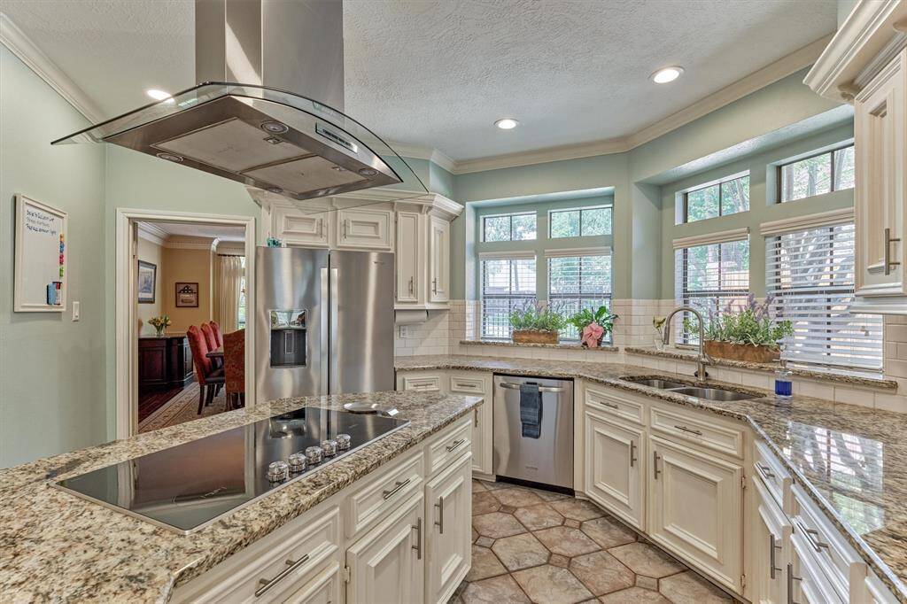 Extended kitchen view highlights abundant counter space, bay windows, and connection to the formal dining room—ideal for entertaining.