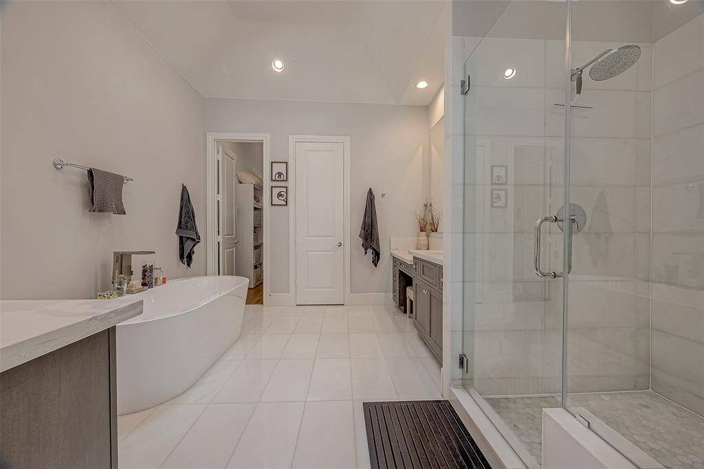 The dreamy primary bath features double sinks plus vanity space, soaking tub, seamless shower and a walk-in closet.