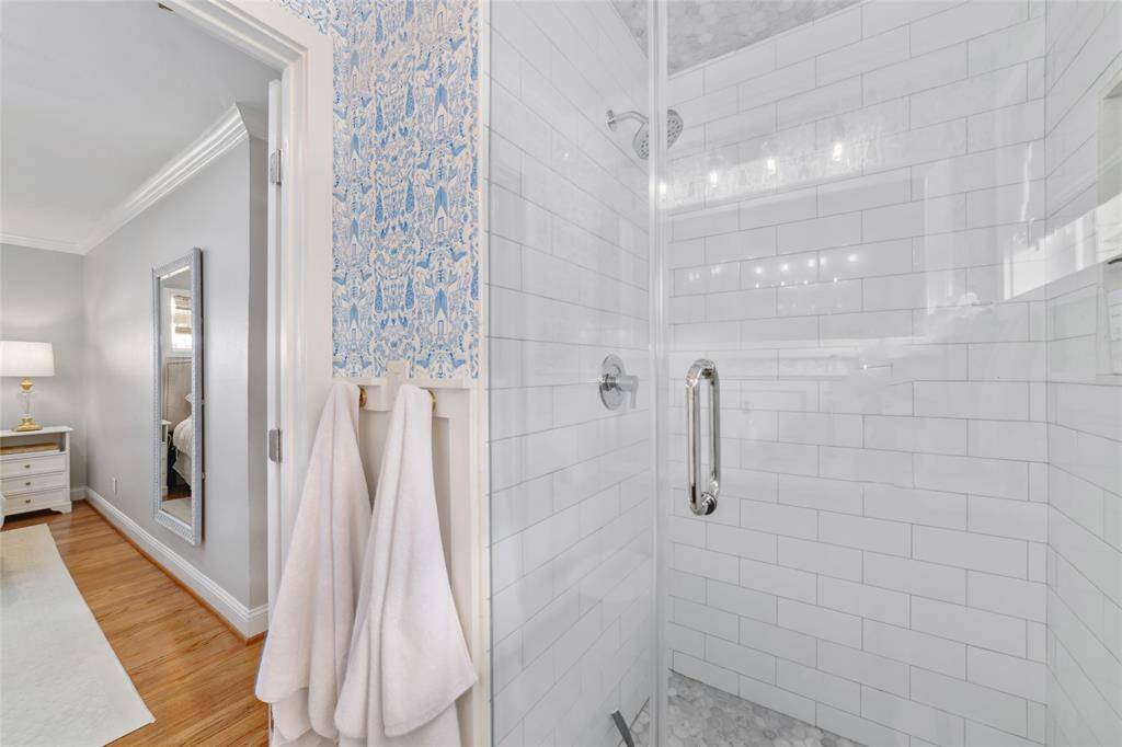 Start your day in this crisp walk-in shower with clean white tile and glass doors. It’s bright, modern, and gives just the right touch of spa-day luxury.