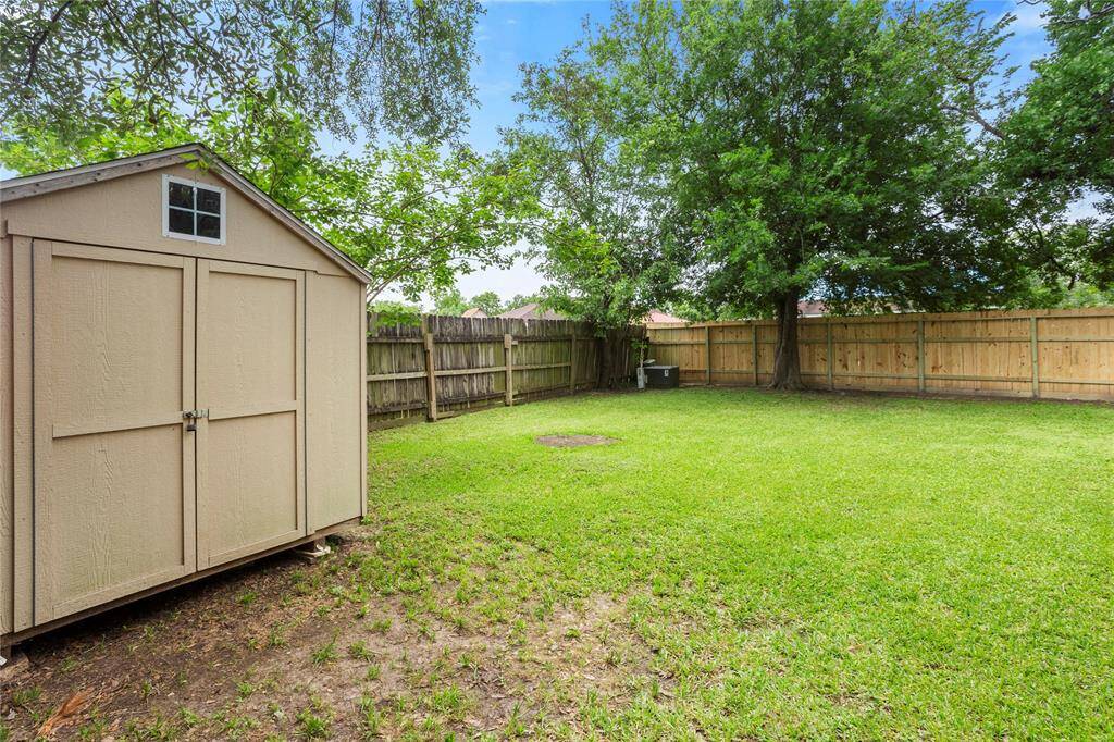 Private fenced in backyard with shed.