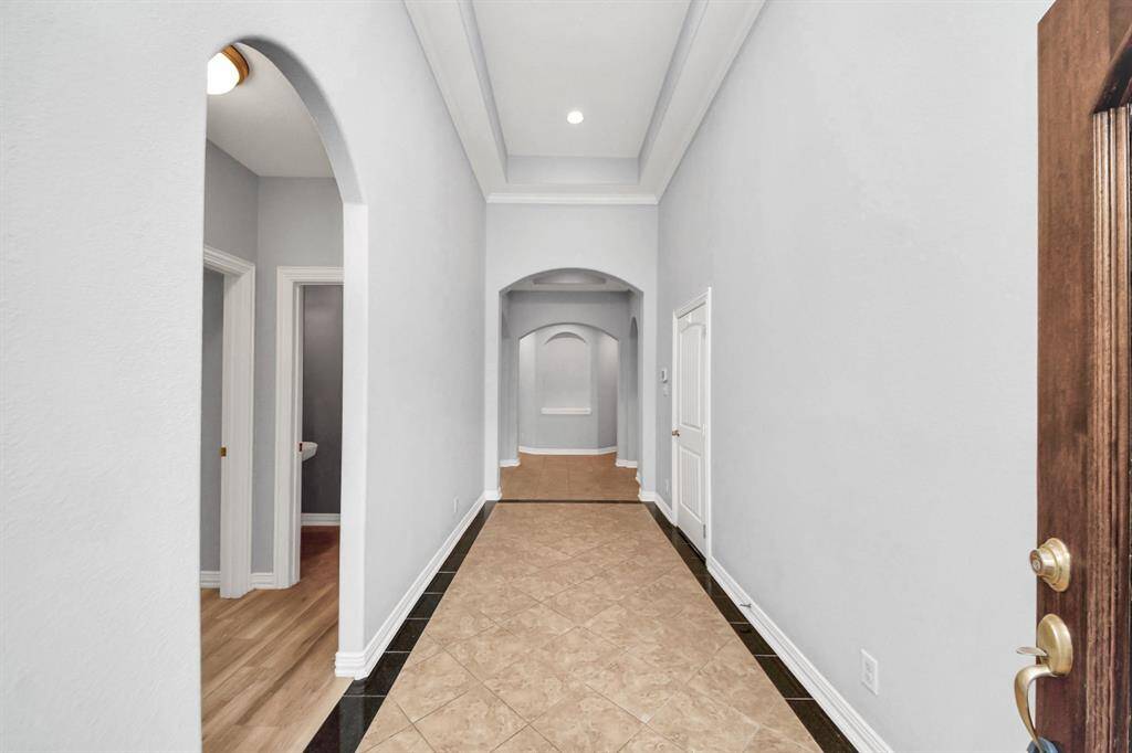 Architectural features such as arched doorways, crown molding, and trayed ceilings are highlights of this stunning home.