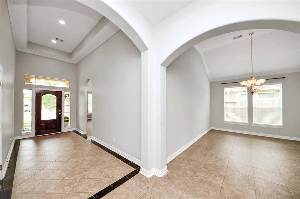 View showcasing the stunning front entry, as well as a glance into the dining room.