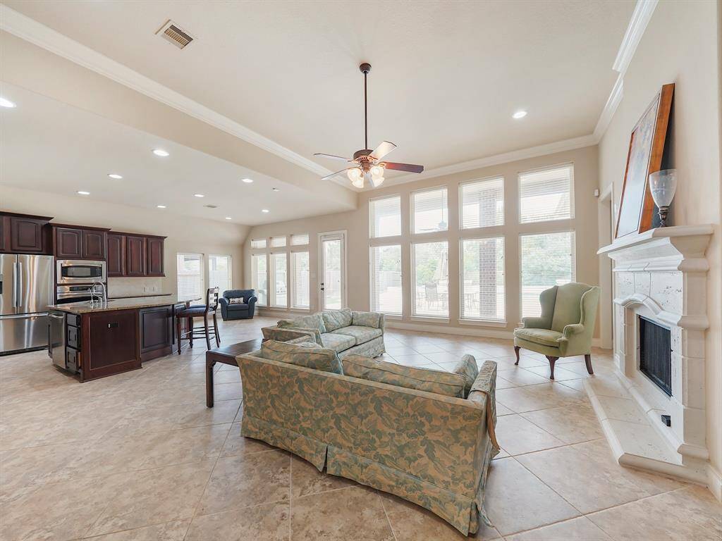 "Indulge in the breathtaking beauty of this home's open-concept living space. Wall-to-wall windows frame a stunning view of your private backyard oasis, flooding the area with natural light. Soaring ceilings, accented by elegant crown molding, create a sense of grandeur. Enjoy effortless living with the durable and stylish tile flooring that flows seamlessly throughout this space!