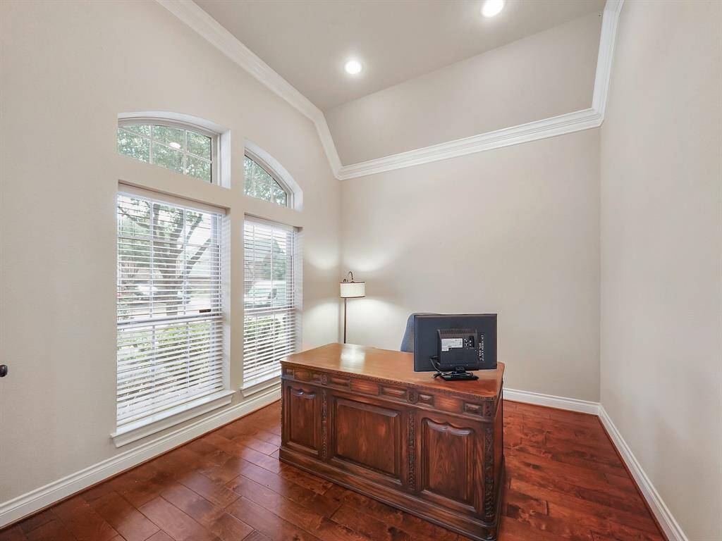 Step through the french doors off the entry into a spacious private office, complete with soaring ceilings and stunning arched windows. A perfect space for work or relaxation.