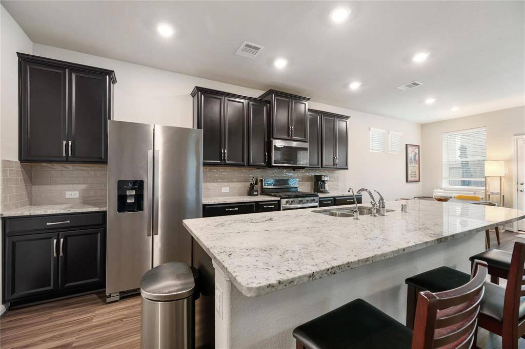 And this stunning kitchen with light granite countertops, stainless steel appliances, and gas range for cooking.